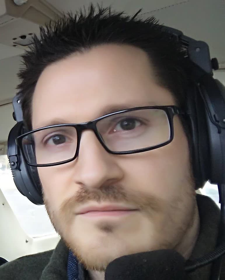 Bryce Dazell, wearing an aviation headset in the cockpit of a small plane